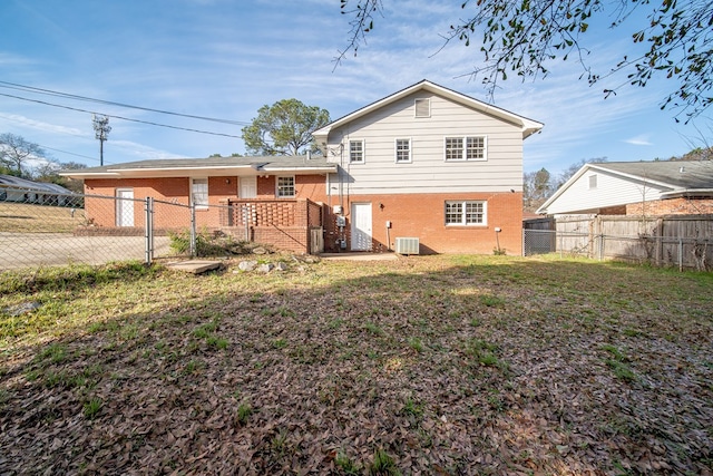 back of house with a yard and central AC