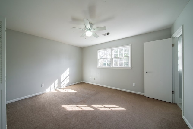 unfurnished room with ceiling fan and light carpet