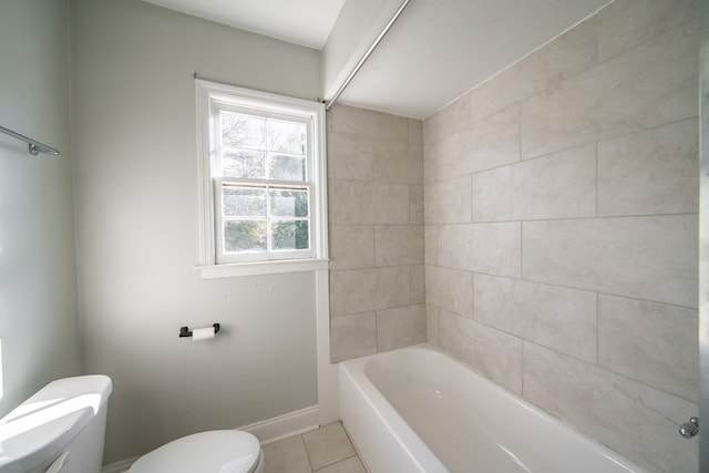 bathroom with tiled shower / bath, tile patterned floors, and toilet