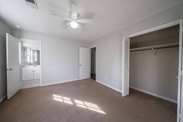 unfurnished bedroom with connected bathroom, sink, ceiling fan, light carpet, and a closet