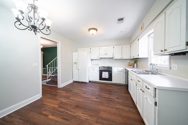 kitchen with sink, hanging light fixtures, white fridge with ice dispenser, white cabinets, and oven