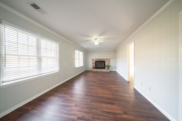 unfurnished living room featuring dark wood-type flooring, ceiling fan, ornamental molding, and a brick fireplace