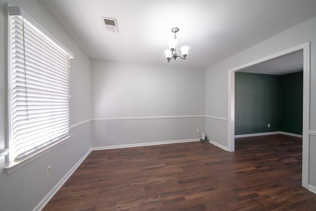 unfurnished room with dark hardwood / wood-style flooring and a chandelier