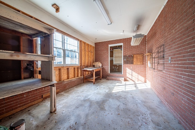 miscellaneous room with concrete floors and brick wall