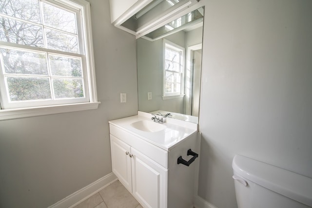 bathroom featuring a healthy amount of sunlight, toilet, tile patterned flooring, and vanity