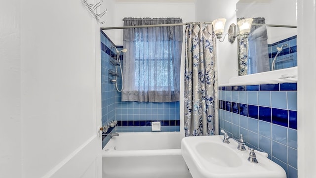 bathroom featuring sink, tile walls, and shower / tub combo