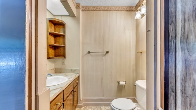 bathroom featuring vanity, a textured ceiling, and toilet