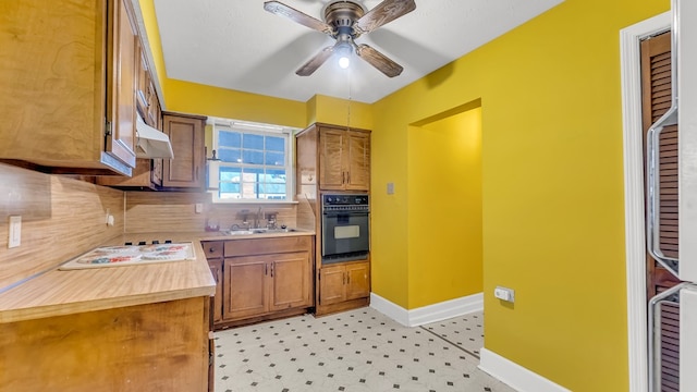 kitchen with sink, white electric cooktop, ceiling fan, oven, and decorative backsplash