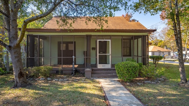 view of front of home featuring a front lawn and a sunroom