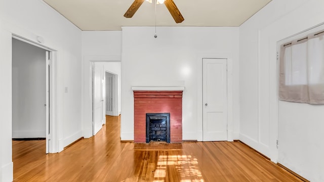 unfurnished living room with hardwood / wood-style flooring, a fireplace, and ceiling fan