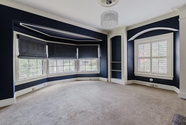 empty room with carpet floors, crown molding, baseboards, and an inviting chandelier