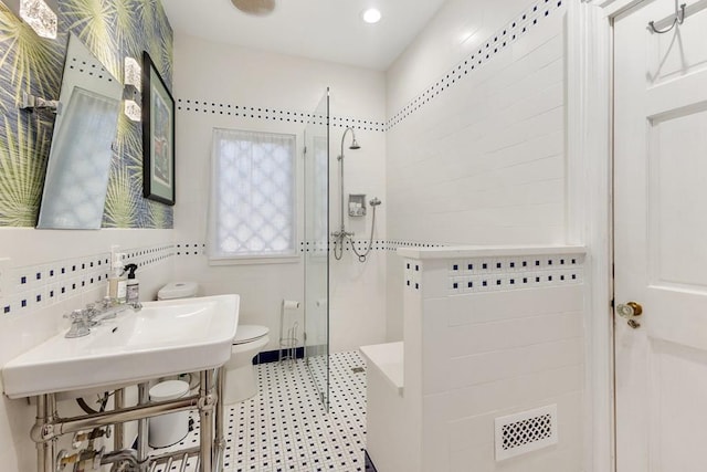 full bath featuring tile walls, toilet, a sink, a walk in shower, and backsplash