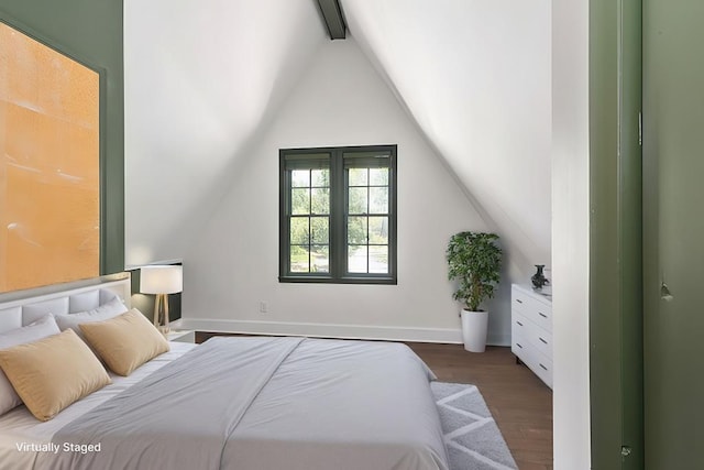 bedroom with dark wood-style floors, vaulted ceiling with beams, and baseboards