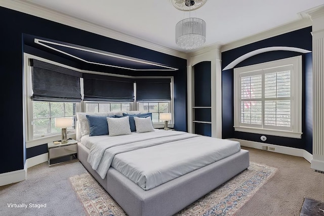 carpeted bedroom featuring crown molding, baseboards, and a notable chandelier