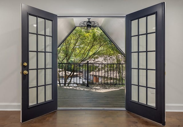 doorway featuring dark wood-type flooring and baseboards