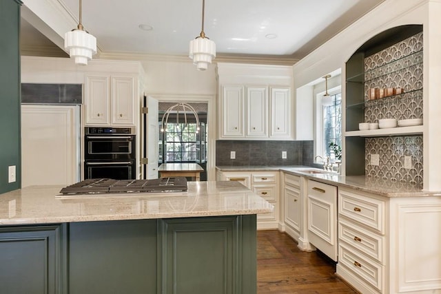 kitchen featuring dobule oven black, a peninsula, decorative light fixtures, and light stone countertops