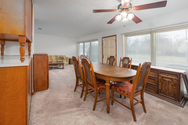 dining area featuring a ceiling fan and light colored carpet