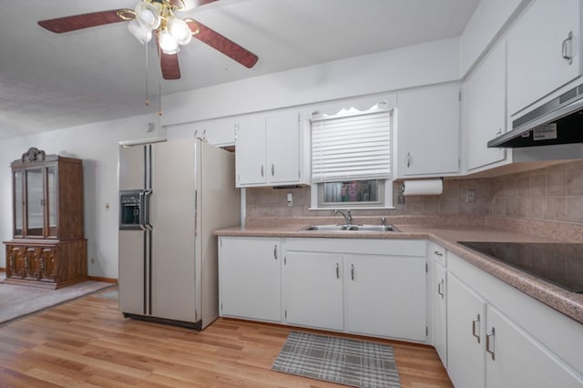 kitchen with white refrigerator with ice dispenser, tasteful backsplash, light wood-style floors, white cabinetry, and a sink