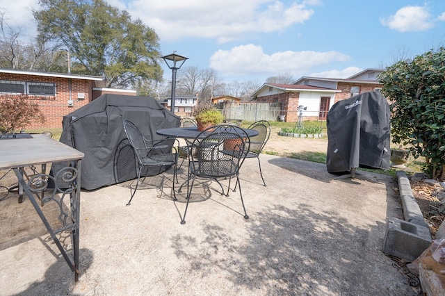 view of patio with grilling area, fence, and outdoor dining area