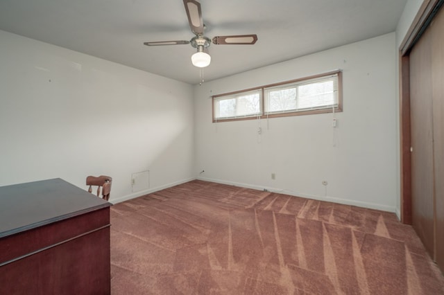 interior space featuring a ceiling fan, carpet flooring, and baseboards