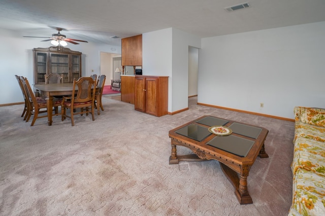 interior space with baseboards, visible vents, and light colored carpet