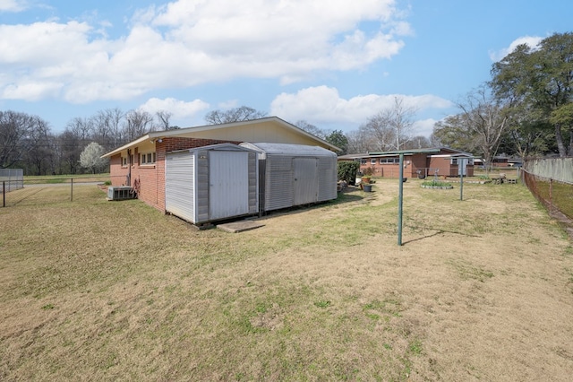 view of yard with an outbuilding, a shed, and fence