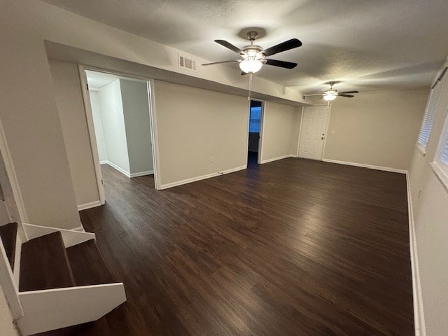 unfurnished living room featuring dark wood finished floors, a textured ceiling, baseboards, and ceiling fan