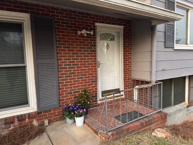 property entrance featuring brick siding