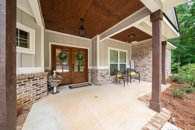 11602 Ga Highway 0085, Waverly Hall, GA 31831 - doorway to property featuring brick siding, french doors, board and batten siding, and covered porch