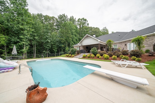 11602 Ga Highway 0085, Waverly Hall, GA 31831 - swimming pool featuring a diving board, a patio area, and view of scattered trees