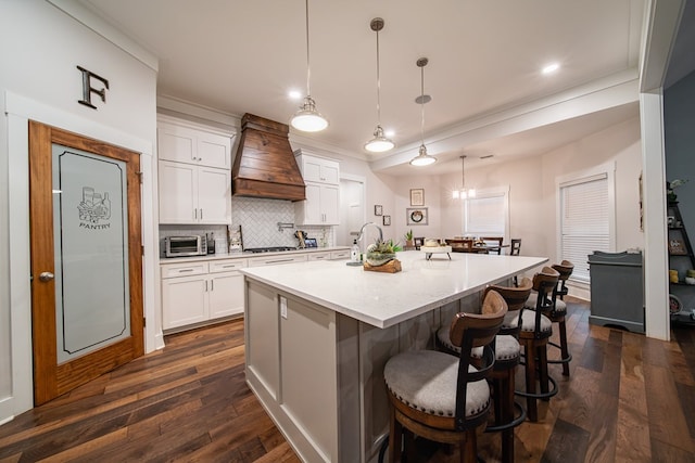 11602 Ga Highway 0085, Waverly Hall, GA 31831 - kitchen featuring wall chimney range hood, dark wood finished floors, a kitchen bar, backsplash, and a large island