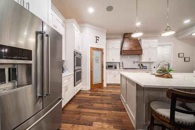 11602 Ga Highway 0085, Waverly Hall, GA 31831 - kitchen featuring stainless steel appliances, custom exhaust hood, dark wood-style floors, tasteful backsplash, and a breakfast bar area