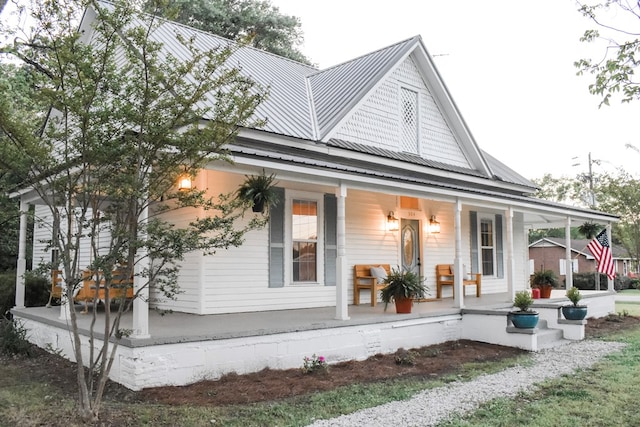 farmhouse featuring metal roof and covered porch