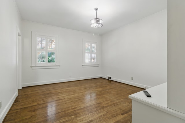 unfurnished room featuring ornamental molding, dark wood-style floors, a chandelier, and baseboards
