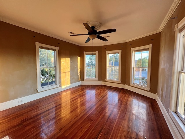 empty room with a wealth of natural light, crown molding, ceiling fan, and dark hardwood / wood-style floors