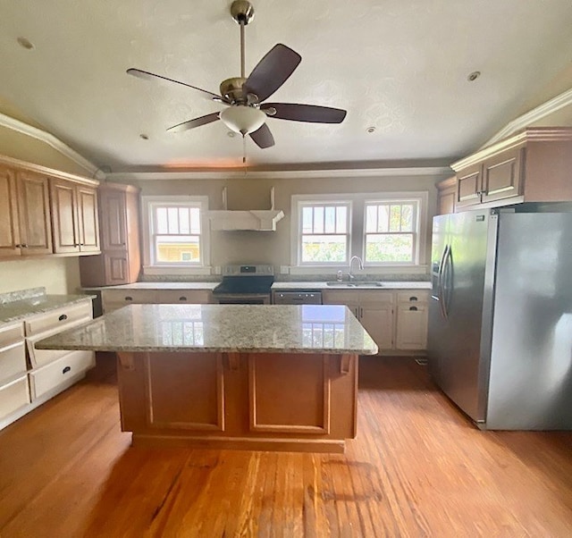 kitchen featuring sink, a center island, stainless steel appliances, and light hardwood / wood-style floors
