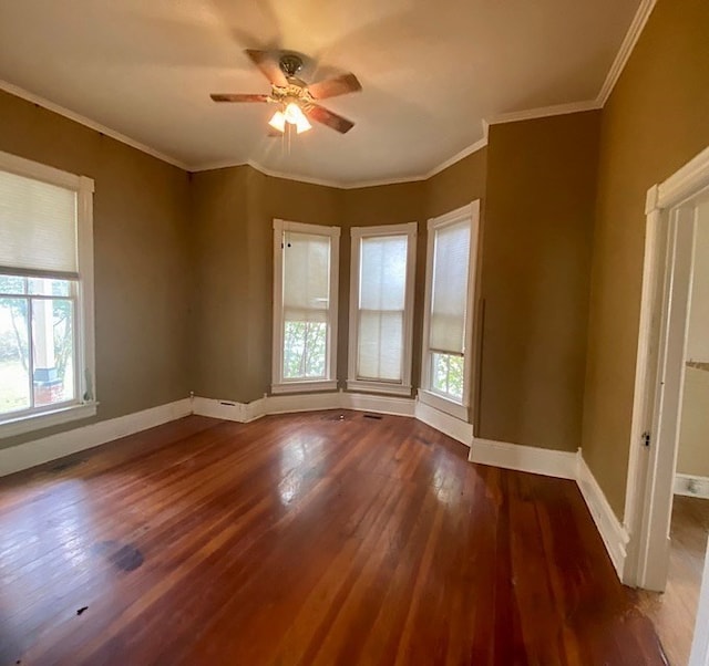 empty room with dark hardwood / wood-style floors, crown molding, ceiling fan, and a healthy amount of sunlight