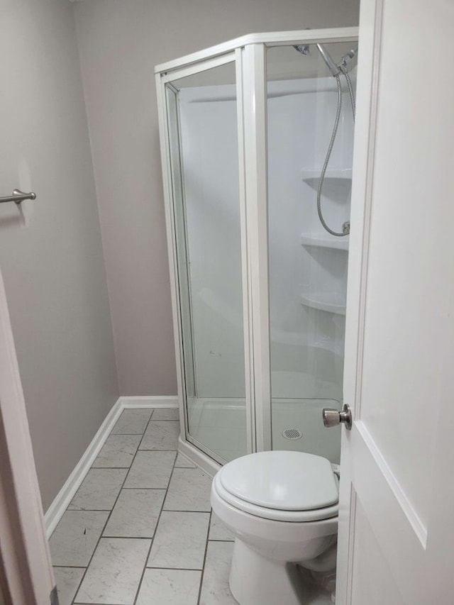 bathroom with a shower with door and toilet