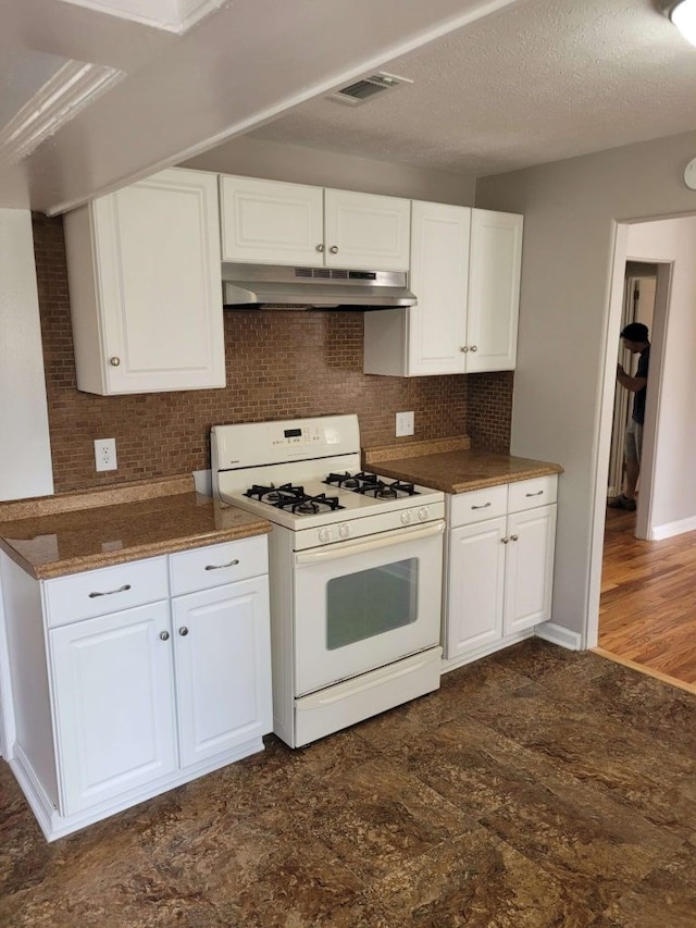 kitchen with white cabinets, decorative backsplash, and white gas range oven