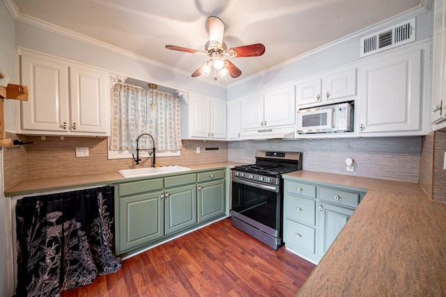 22 Oak Dr, Pine Mountain, GA 31822 - kitchen with stainless steel gas stove, white microwave, white cabinets, dark wood finished floors, and crown molding