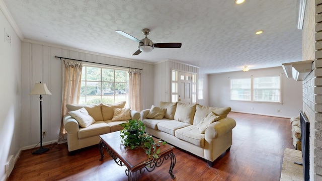 3224 Carden Dr, Columbus, GA 31907 - living room featuring crown molding, wood finished floors, a ceiling fan, a fireplace, and a textured ceiling