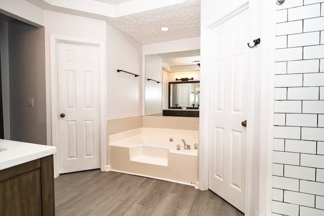2 Labrador Ct, Columbus, GA 31909 - full bathroom featuring a garden tub, wood finished floors, vanity, a textured ceiling, and recessed lighting
