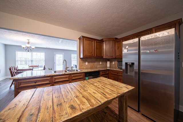 37 Oakwood Dr, Phenix City, AL 36870 - kitchen with appliances with stainless steel finishes, dark wood-style floors, brown cabinets, a peninsula, and a textured ceiling