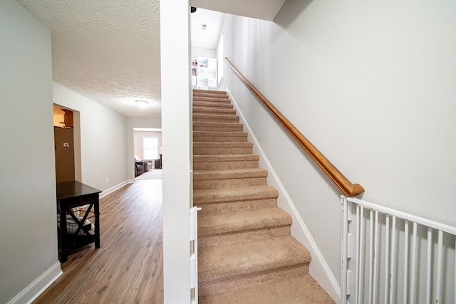 37 Oakwood Dr, Phenix City, AL 36870 - staircase featuring wood finished floors and a textured ceiling