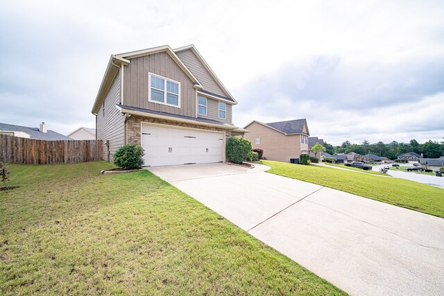 37 Oakwood Dr, Phenix City, AL 36870 - view of front facade featuring a garage, board and batten siding, driveway, and stone siding