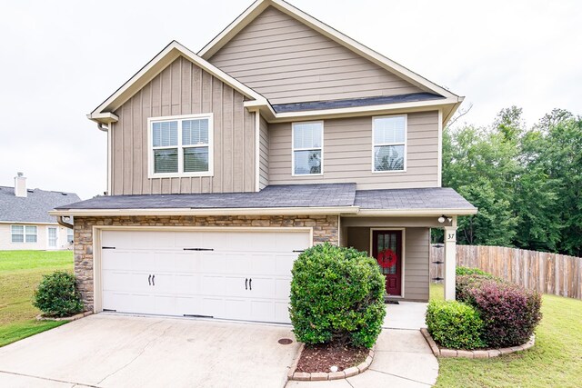 37 Oakwood Dr, Phenix City, AL 36870 - view of front of property with an attached garage, concrete driveway, stone siding, board and batten siding, and a shingled roof