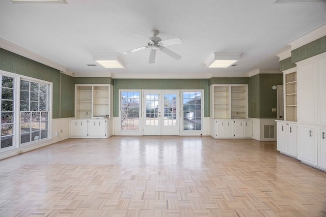 unfurnished living room with french doors, crown molding, a textured ceiling, ceiling fan, and light parquet floors