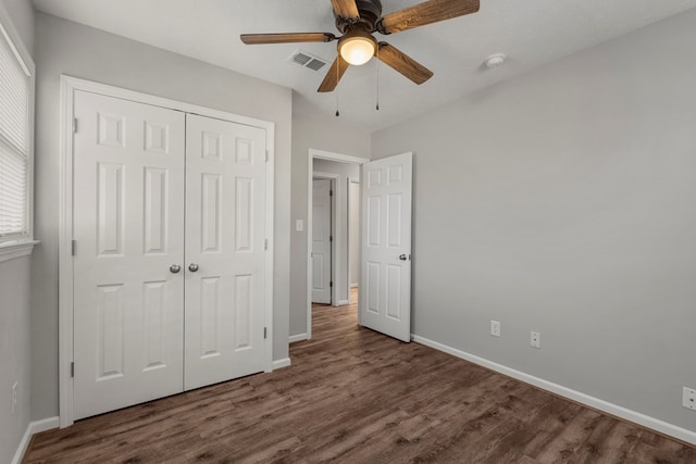 unfurnished bedroom with ceiling fan, a closet, and dark wood-type flooring