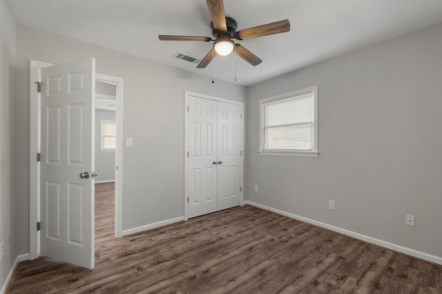 unfurnished bedroom with ceiling fan, a closet, and dark hardwood / wood-style flooring