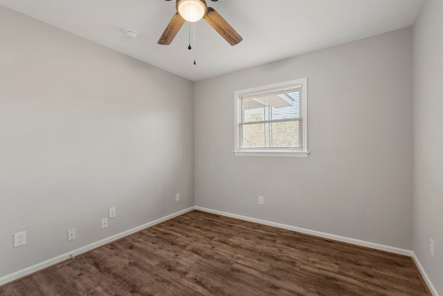 spare room with ceiling fan and dark wood-type flooring